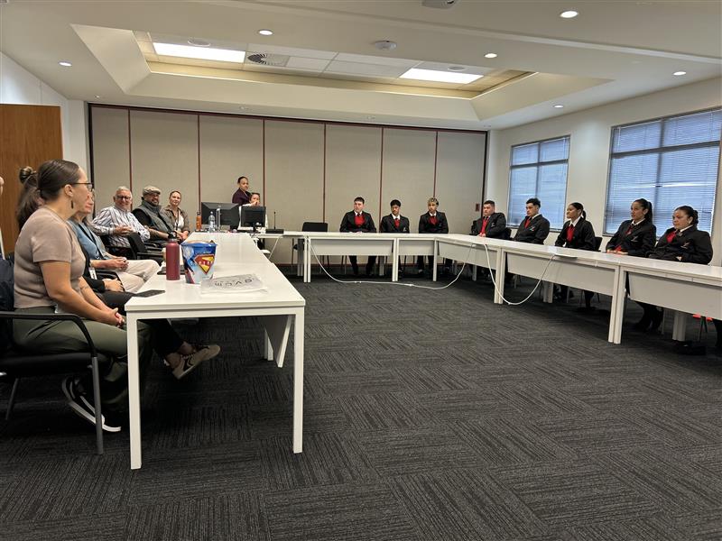 students and staff sit in council meeting room sharing ideas
