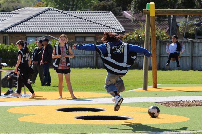 A child leaps from one small in-ground trampoline to another.